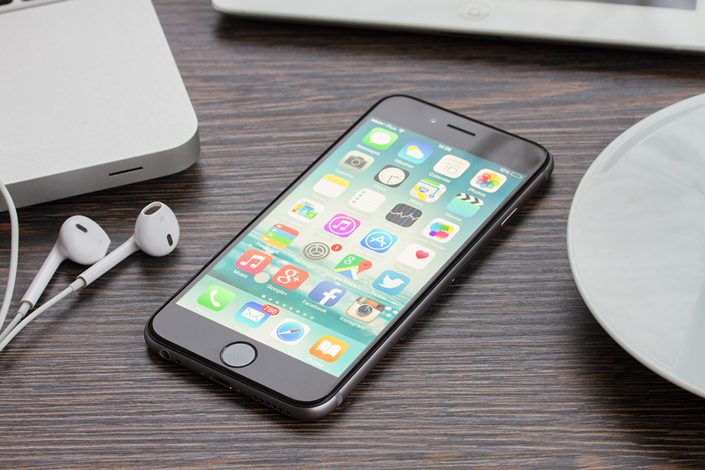 Curso de Design Gráfico: Novo Apple Iphone 6 na cor preta do espaço cinza na mesa de trabalho